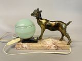 a statue of a dog with a ball on a stand