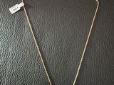 a gold necklace with a red stone on it