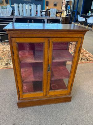 une vitrine en bois avec des portes vitrées et des étagères dans un magasin