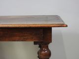 an old wooden table with a wooden top and turned legs