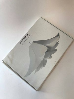an image of a book on a white table with a bird on it
