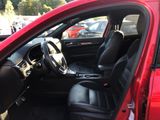 the interior of a red car with black leather seats and a steering wheel