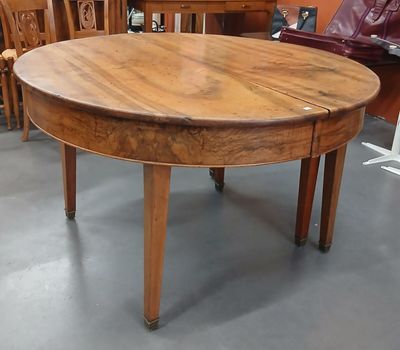 une table ronde avec un plateau en bois au milieu d'une pièce