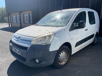 the small white van is parked in front of a building