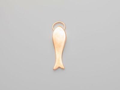 un pendentif en forme de poisson plaqué or sur fond gris
