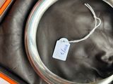 a silver bracelet in a box with a tag on it