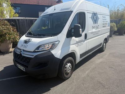 une camionnette blanche garée sur un parking à côté d'une maison