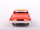 a red toy car that is sitting on a white surface