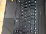 a black laptop with a yellow sticker on the keyboard