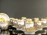 several cups and saucers are lined up on a black table