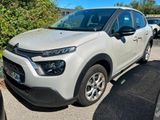 La Citroën blanche est garée sur un parking avec d'autres voitures