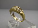 une photo d'une bague en or et diamants posée sur un socle transparent