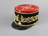 a red and black hat with a gold design on it
