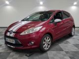La Ford Fiesta rouge est garée sur un sol en carrelage à damier.