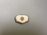 un plat ancien en argent orné d'un emblème blanc et doré