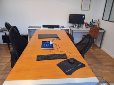 un bureau sur lequel se trouvent un ordinateur portable, un clavier, une souris et un écran