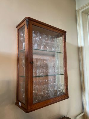 a glass display case with wine glasses inside of it