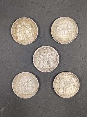 six pièces britanniques différentes sont disposées en cercle sur une surface noire