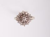 une bague en or blanc ornée d'un diamant central brun et blanc