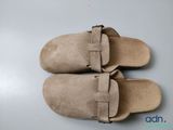 pair of tan sued slippers with buckles on them on a white surface