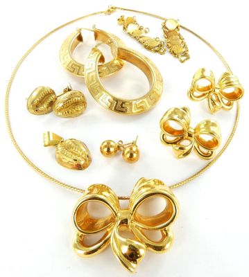 une photo représentant une collection de bijoux en or posés sur une surface blanche