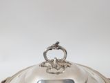 an antique silver plate covered with a metal lid and a metal handle