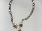un gros plan d'un collier sur une surface blanche avec un fond blanc