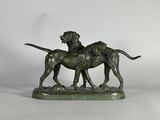 une statue en bronze représentant deux chiens, posée sur un socle en marbre