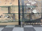 two glass shelves with birds on them in a room
