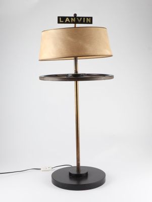 une lampe noire surmontée d'un abat-jour beige
