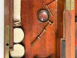 an old fashioned wooden box with a key and other items in it