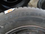 a tire with a sticker on it sitting on a pile of tires