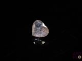 a close up of a heart shaped diamond on a black surface