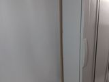 a white refrigerator in the corner of a room