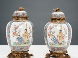 pair of chinese vases with figures on stands on a table