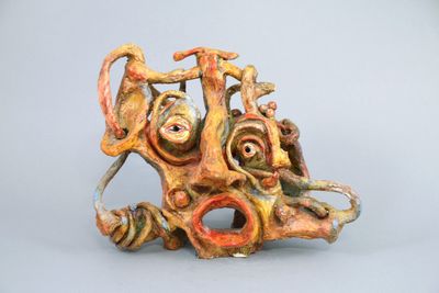 a sculpture of a face made out of clay on a table