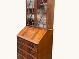 un vieux bureau en bois avec des portes vitrées et des tiroirs