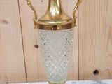 a gold vase sitting on top of a marble table