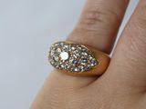 an image of a woman ' s hand holding a gold ring with diamonds