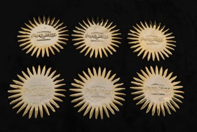 six rayons de soleil sculptés en ivoire sur fond noir
