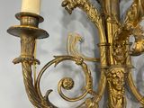 a gold colored candle holder with two candles on it