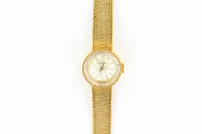 une image d'un gros plan d'une montre-bracelet sur une surface blanche