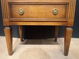 a small wooden table with a drawer on it