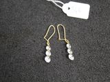 une paire de boucles d'oreilles posée sur une surface noire, avec une étiquette de prix