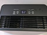 an air conditioner sitting on top of a table next to a white wall
