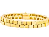 gros plan d'un bracelet en or sur fond blanc