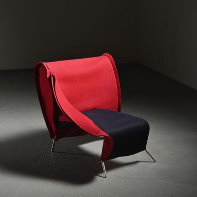 une chaise rouge avec une assise noire dans une pièce sombre
