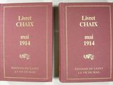 deux livres posés sur une table blanche, avec une couverture rouge et des lettres dorées
