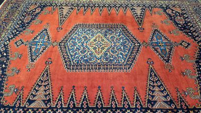 un tapis oriental orange et bleu orné d'un motif en losanges