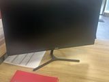 a computer monitor sitting on a desk with a notepad